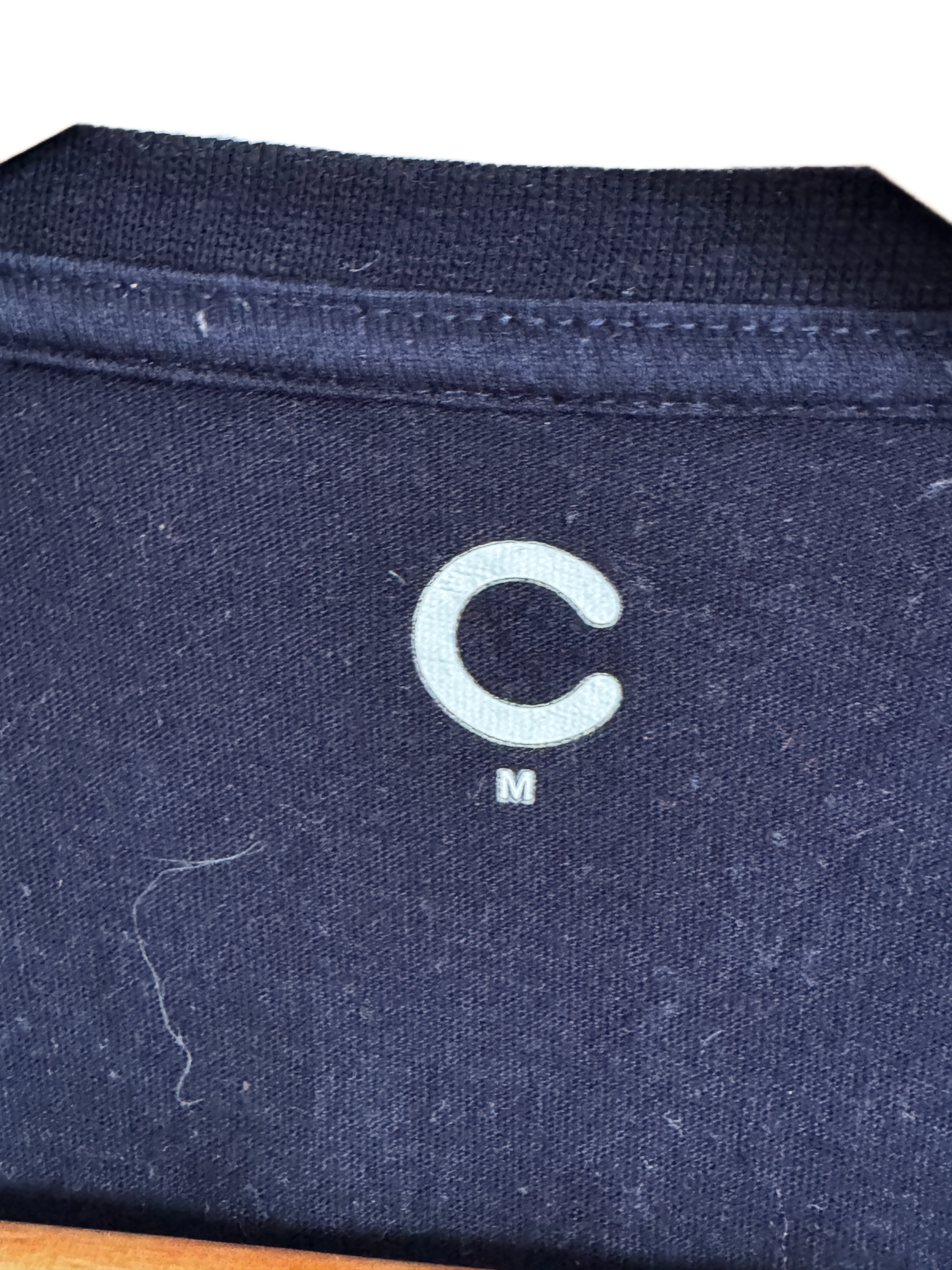 Men's navy blue t-shirt with a unique embroidered cat design on the chest.